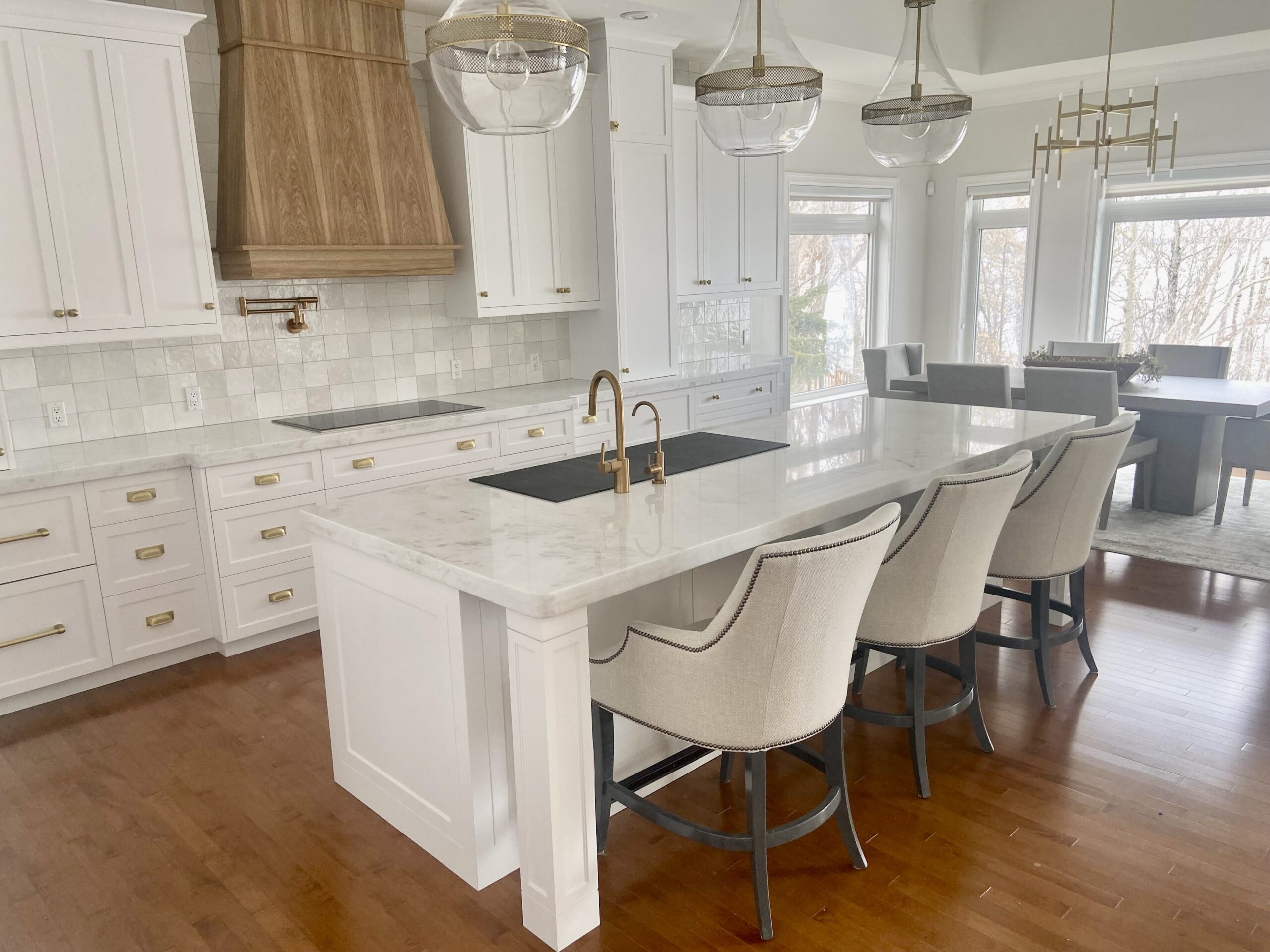 Luxury kitchen with a large marble island and brass fixtures, highlighting the Edmonton free sink countertop promotion.